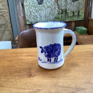 A blue and white sheep mug on a wooden table