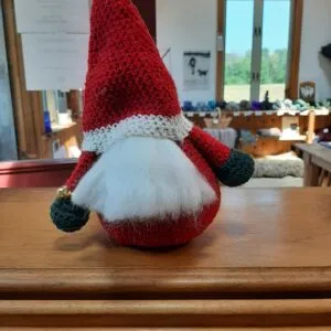 A hand-knit Christmas gnome in red and white wool