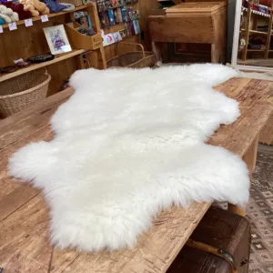 A white sheepskin spread across a wooden table